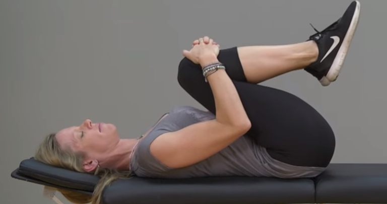 Image of a woman performing a knee to chest stretch