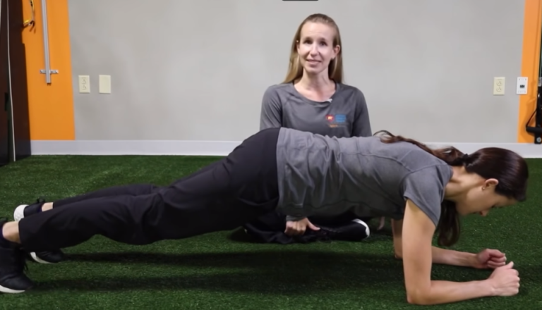 Image of a woman perfoming a plank exercise with a personal trainer